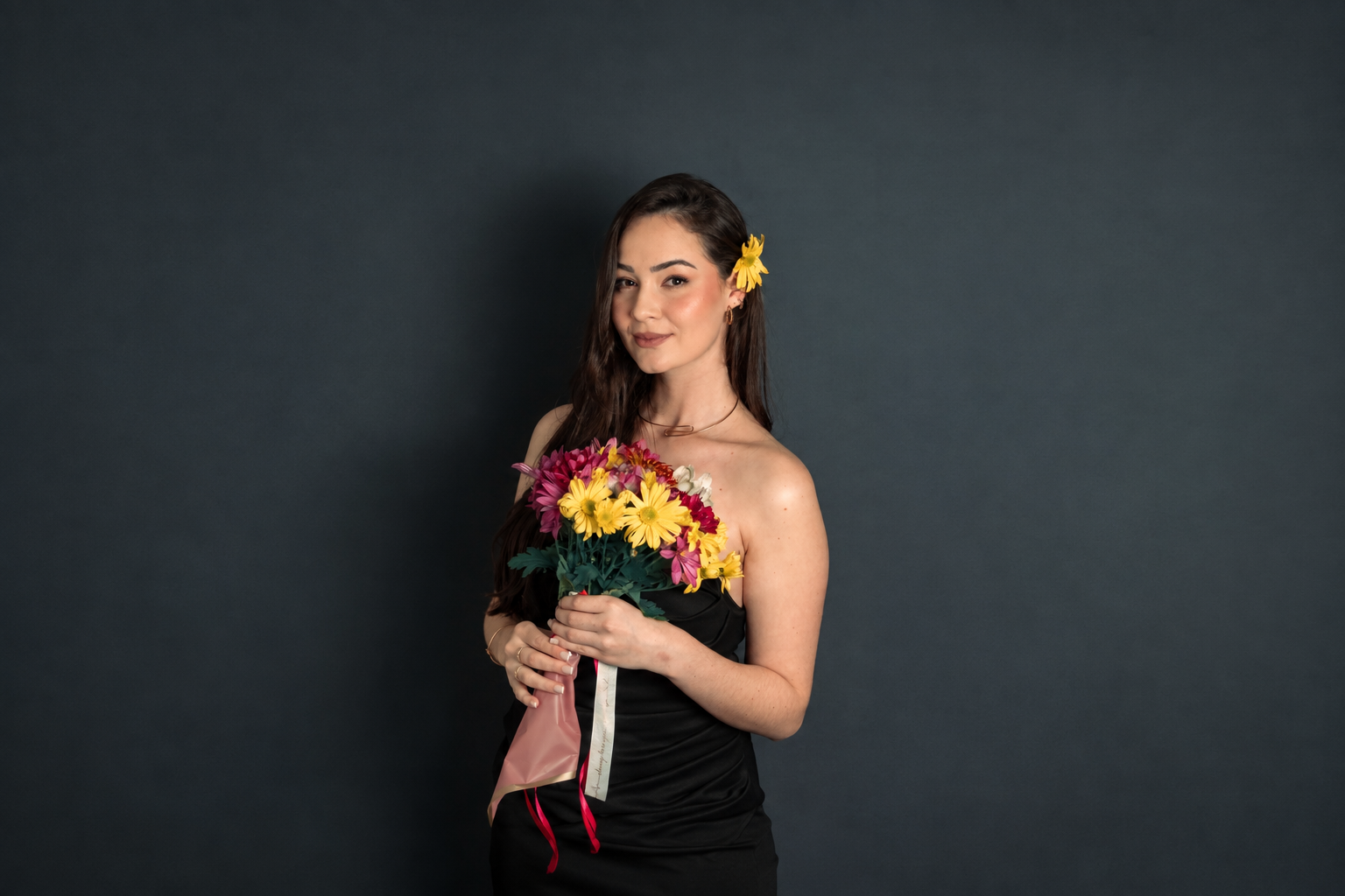Capa Ensaios — modelo segurando buquê de flores em fundo escuro